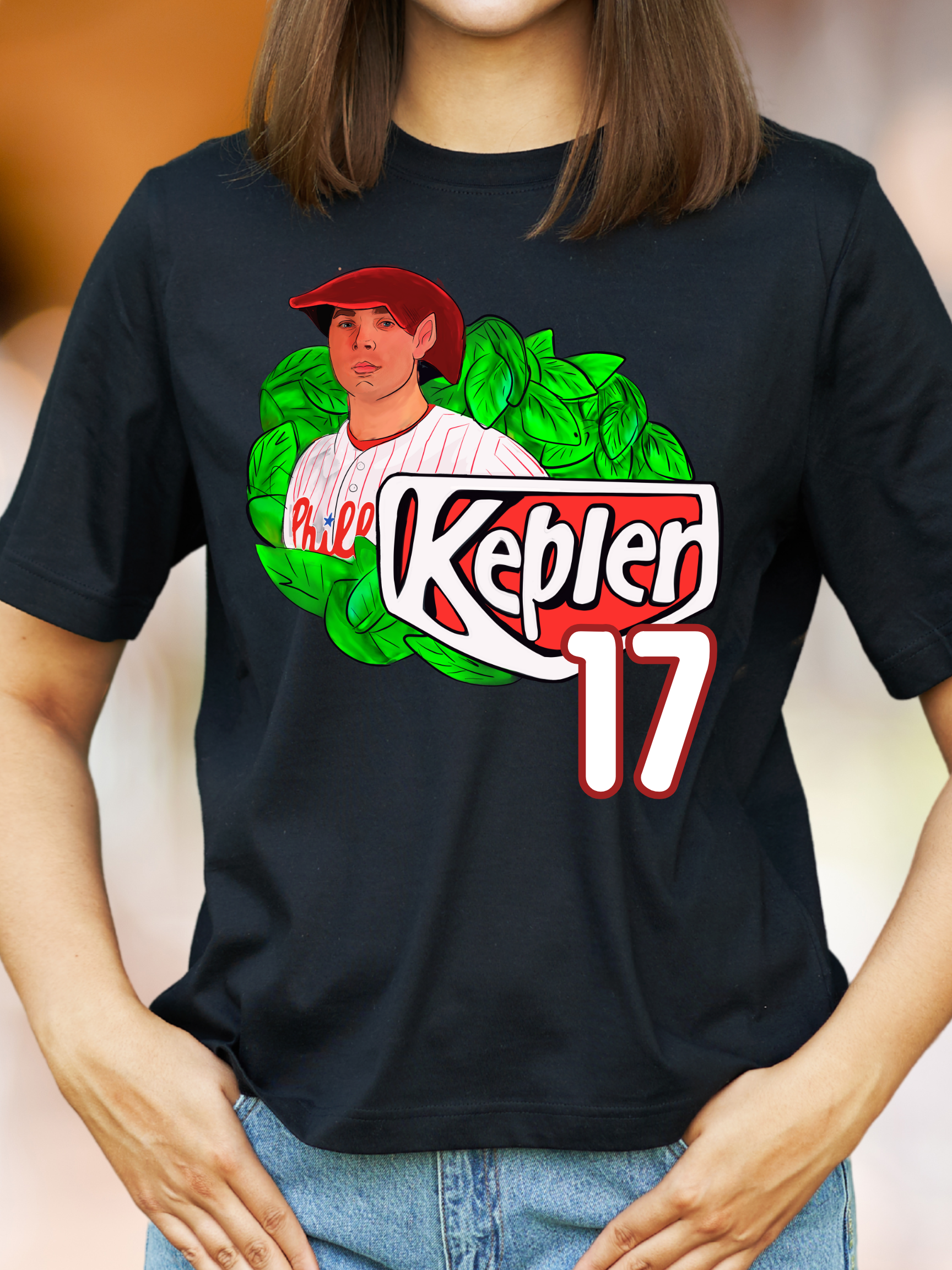 Woman wearing a black t-shirt with an elf-themed fantasy baseball parody graphic that reads "Kepler 17" with leafy background