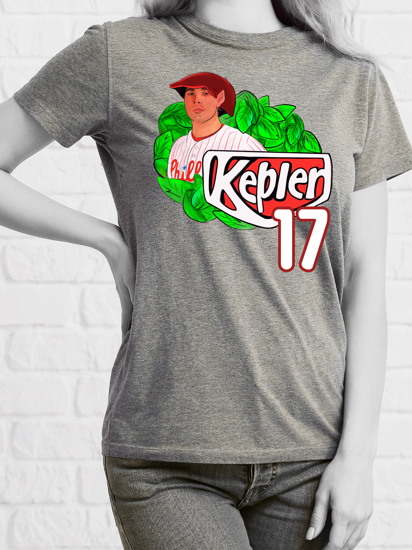 Woman wearing a grey-shirt with an elf-themed fantasy baseball parody graphic that reads "Kepler 17" with leafy background